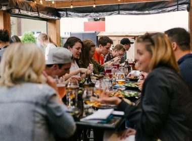 people sitting in front of table talking and eating