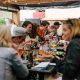 people sitting in front of table talking and eating